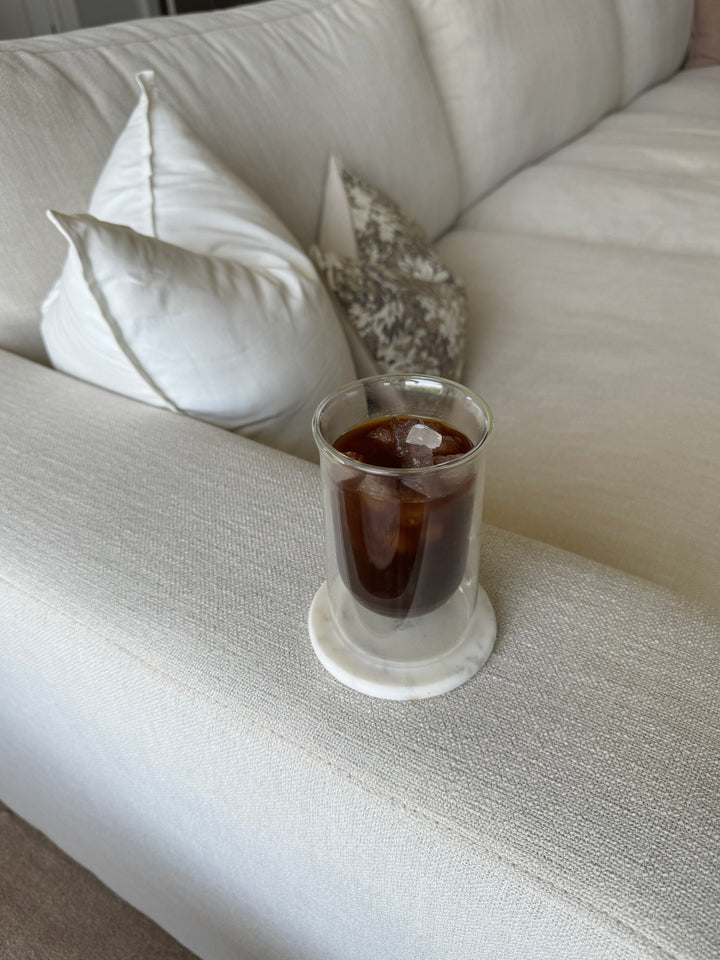 Iced coffee in a double-wall glass on the couch arm